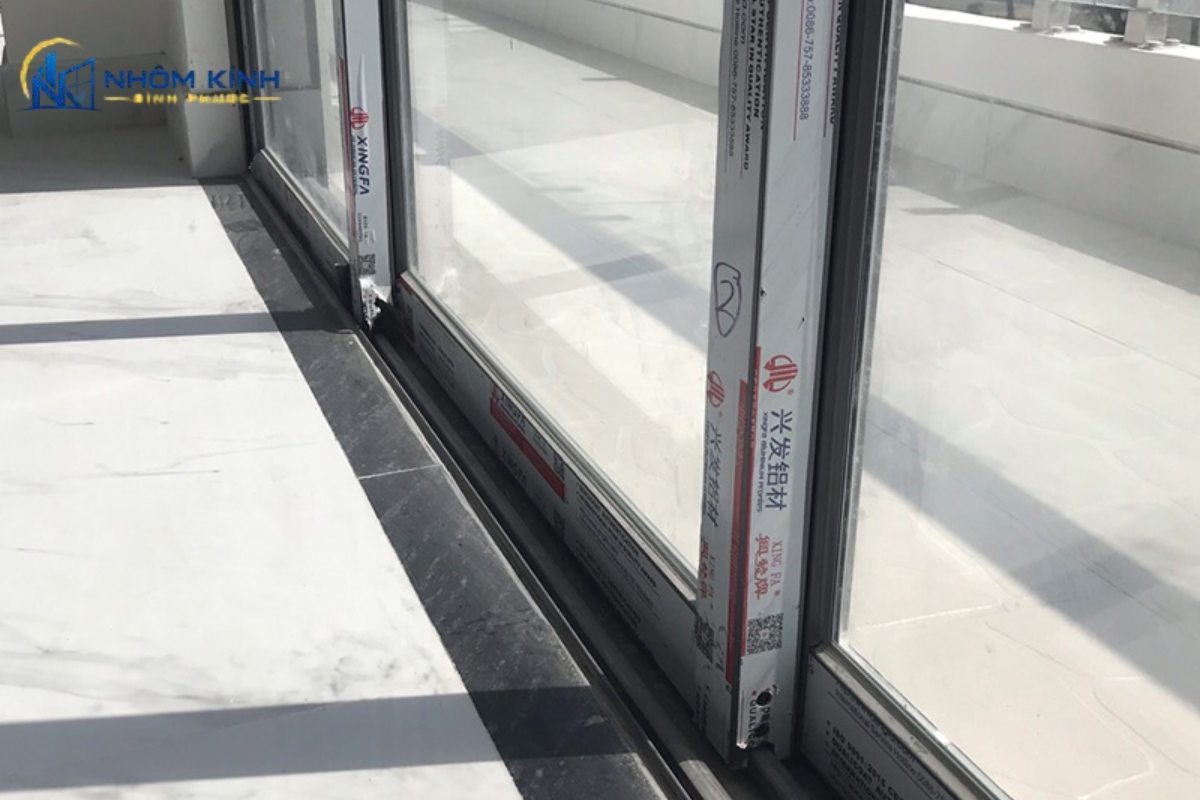 Chi tiết ray trượt, bánh xe chịu lực và hệ khóa đồng bộ của cửa đi mở trượt 3 cánh nhôm xingfa