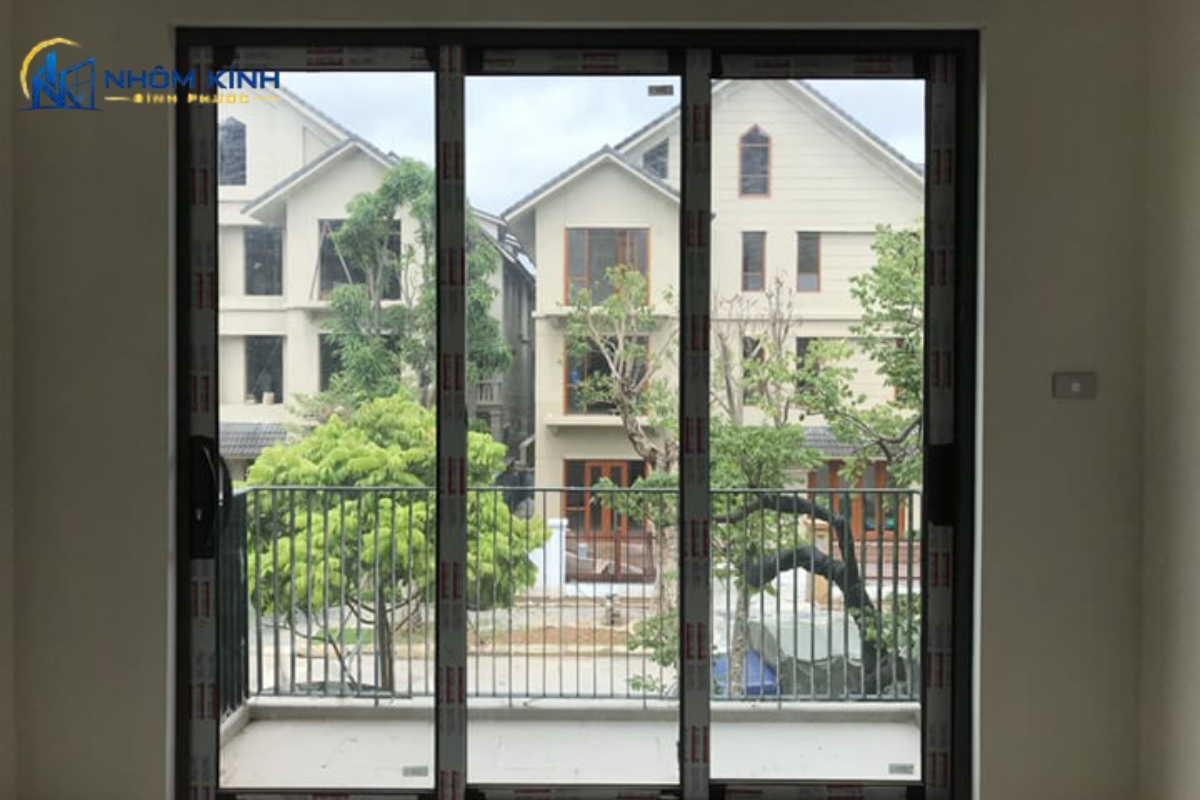 Cửa đi ban công dạng trượt 3 cánh kính giúp đón ánh sáng tự nhiên và mở rộng tầm nhìn, không vướng rèm hay chậu cây, tích hợp rãnh thoát nước chống thấm mưa hiệu quả