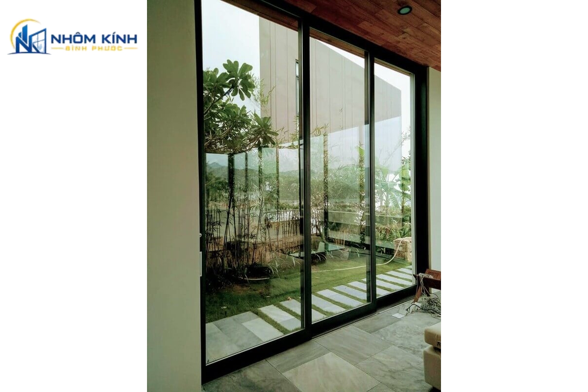 Cửa thông ra sân vườn thiết kế 3 cánh trượt 3 ray giúp mở rộng lối đi kết nối phòng khách và hiên nhà, thuận tiện sinh hoạt gia đình và di chuyển đồ đạc