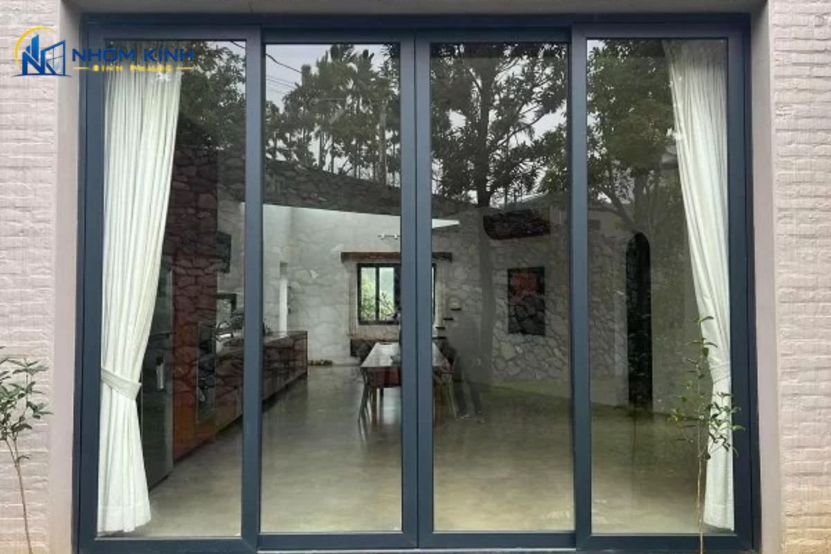Cửa đi mở trượt 4 cánh cấu tạo từ khung nhôm định hình và kính cường lực, vận hành lùa nhẹ nhàng trên hệ ray giúp tối ưu không gian đóng mở