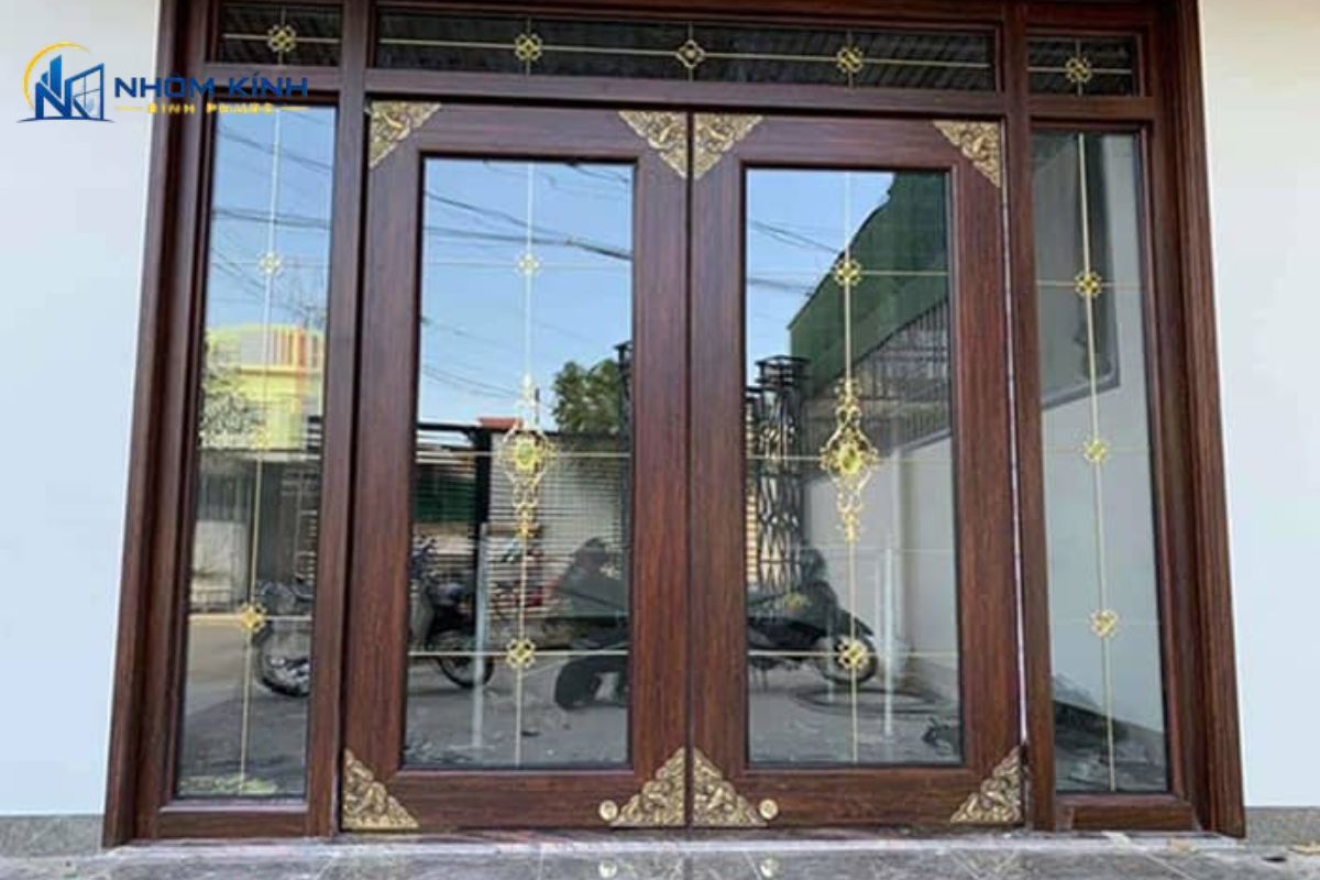 Mẫu cửa thủy lực khung lớn nhôm giả gỗ kết hợp kính suốt và bản lề sàn, mang lại vẻ đẹp hoành tráng, đẳng cấp và sang trọng cho mặt tiền và sảnh chính công trình