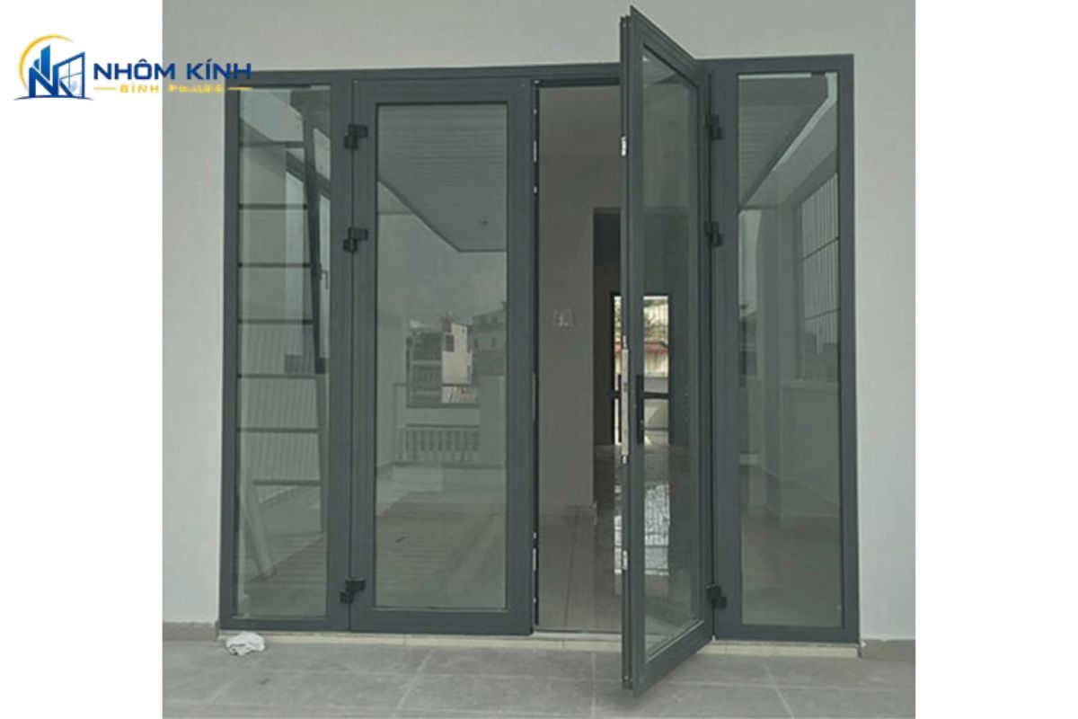 Cửa chính nhà phố dùng cửa nhôm Xingfa 2 cánh hệ 55 kết hợp kính an toàn, khóa đa điểm và có thể bổ sung vách kính cố định để tăng lấy sáng
